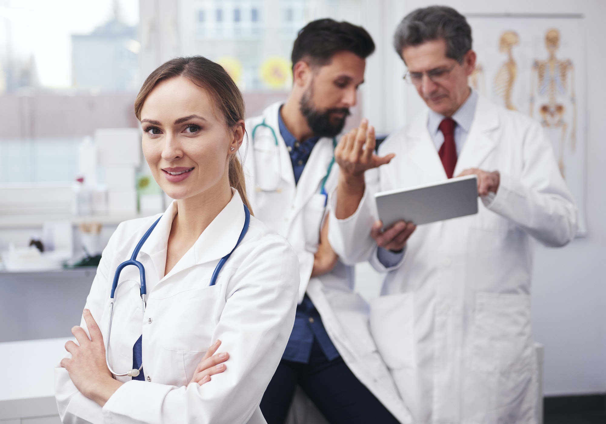three doctors discussing patient care in a clinic