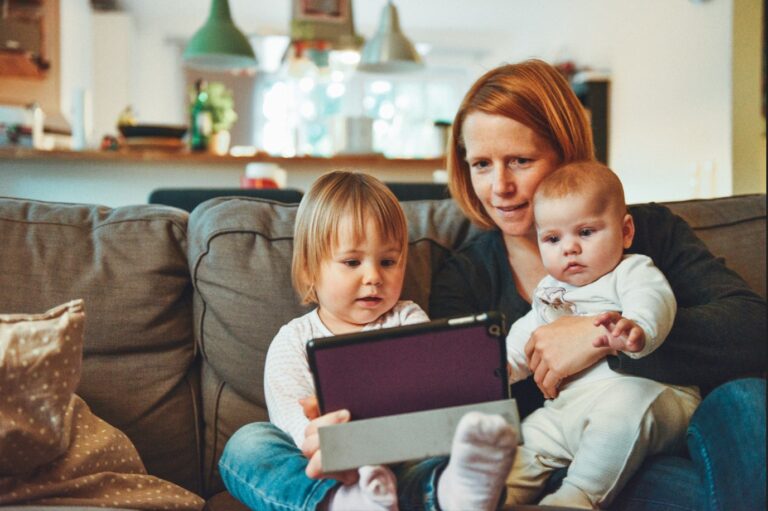 Mom with two kids sitting on a couch doing a telemedicine visit